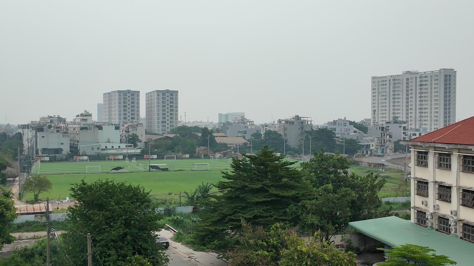Cánh đồng và đất trống xa trung tâm, phía xa là các tòa chung cư