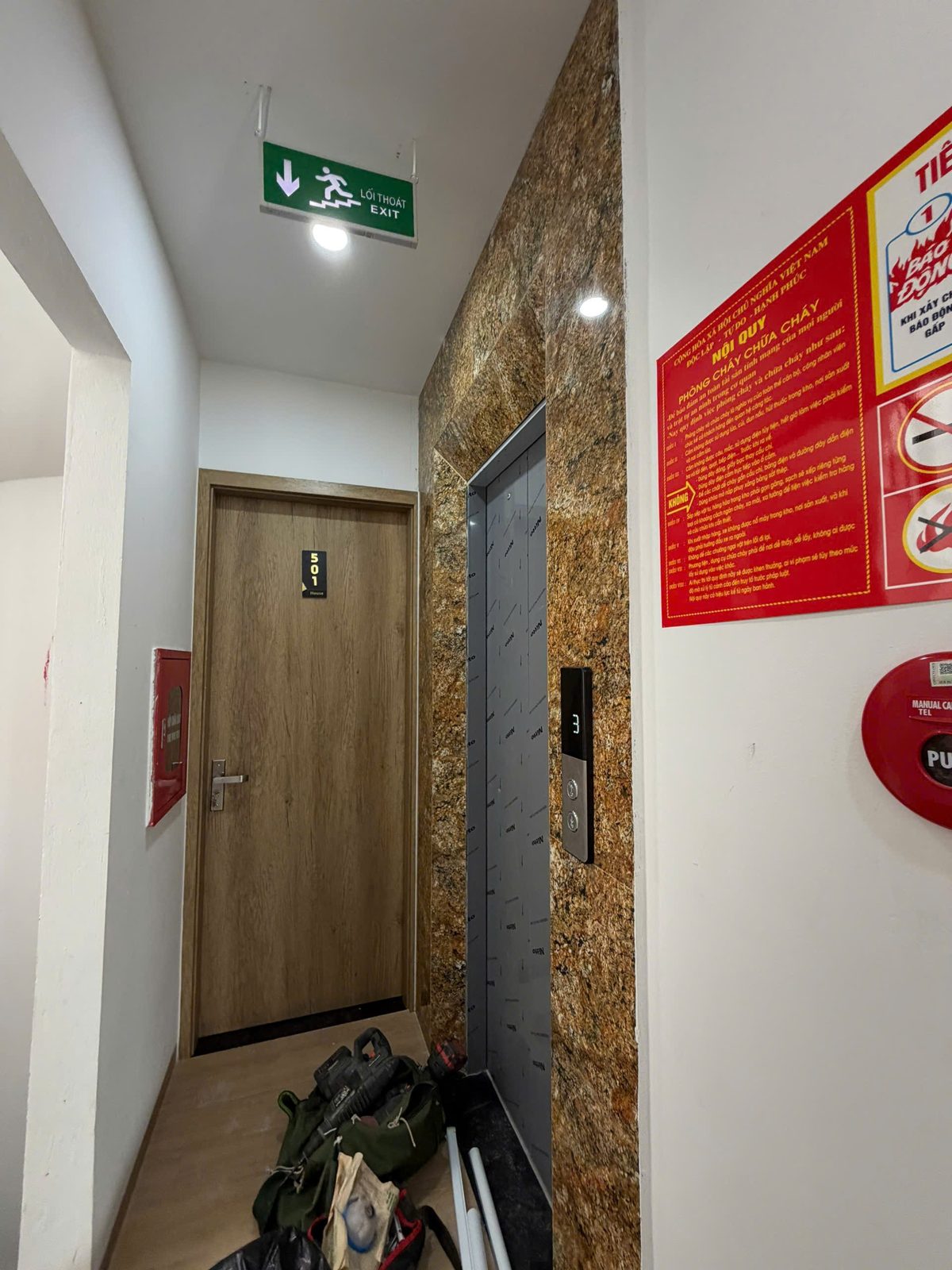 Hành lang tòa nhà cho thuê có biển thoát hiểm, bảng nội quy phòng cháy và bình cứu hỏa
