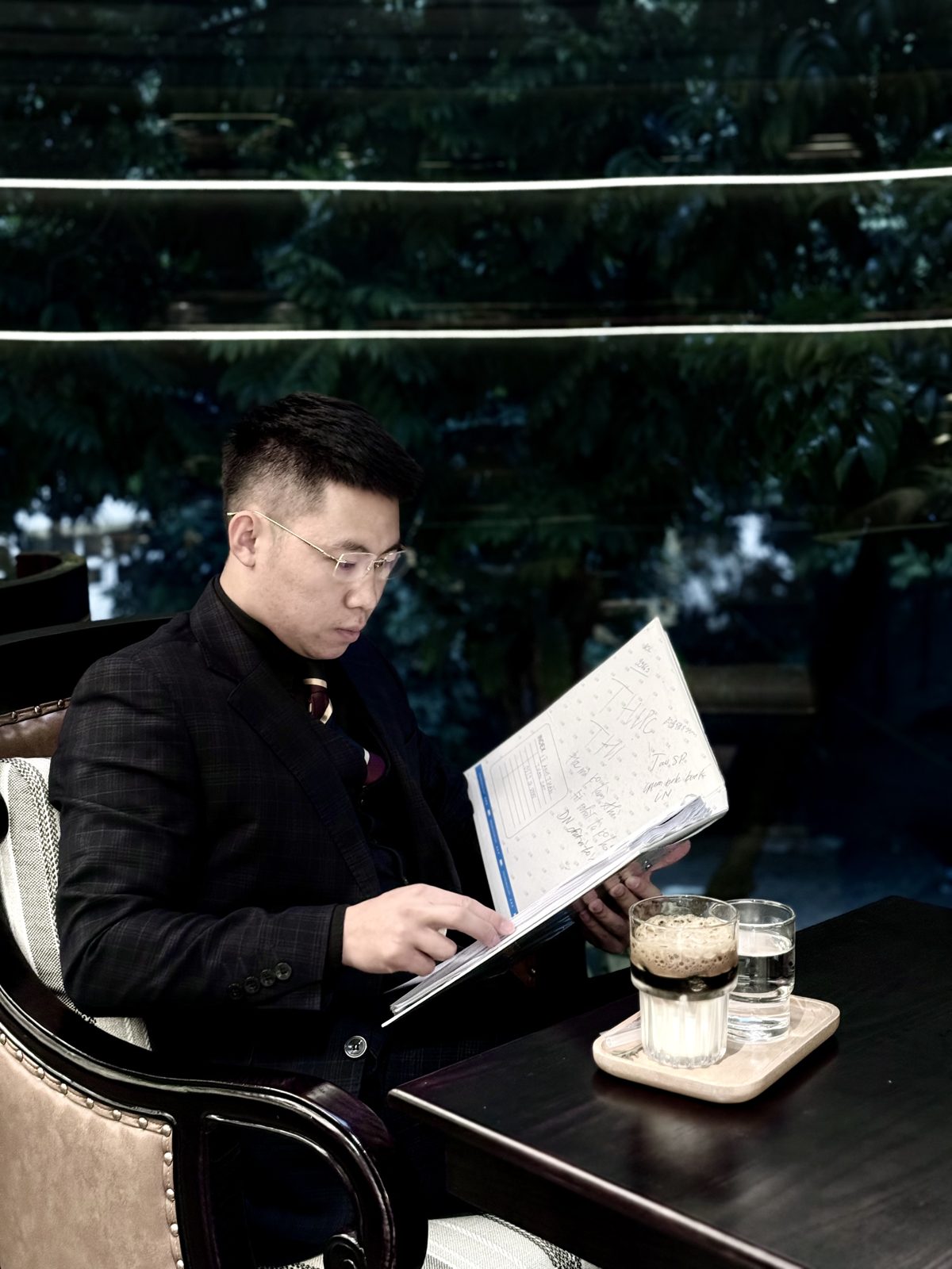 Lê Anh Tuấn ngồi đọc tài liệu bên ly cà phê vào buổi tối
