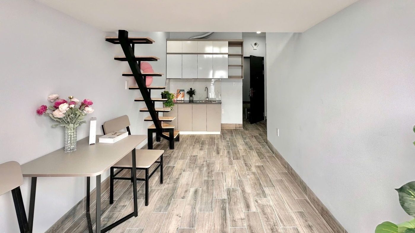 Phòng cho thuê có gác xép, sàn gỗ, bàn ăn và bếp trong tòa 27 phòng ở Bình Tân