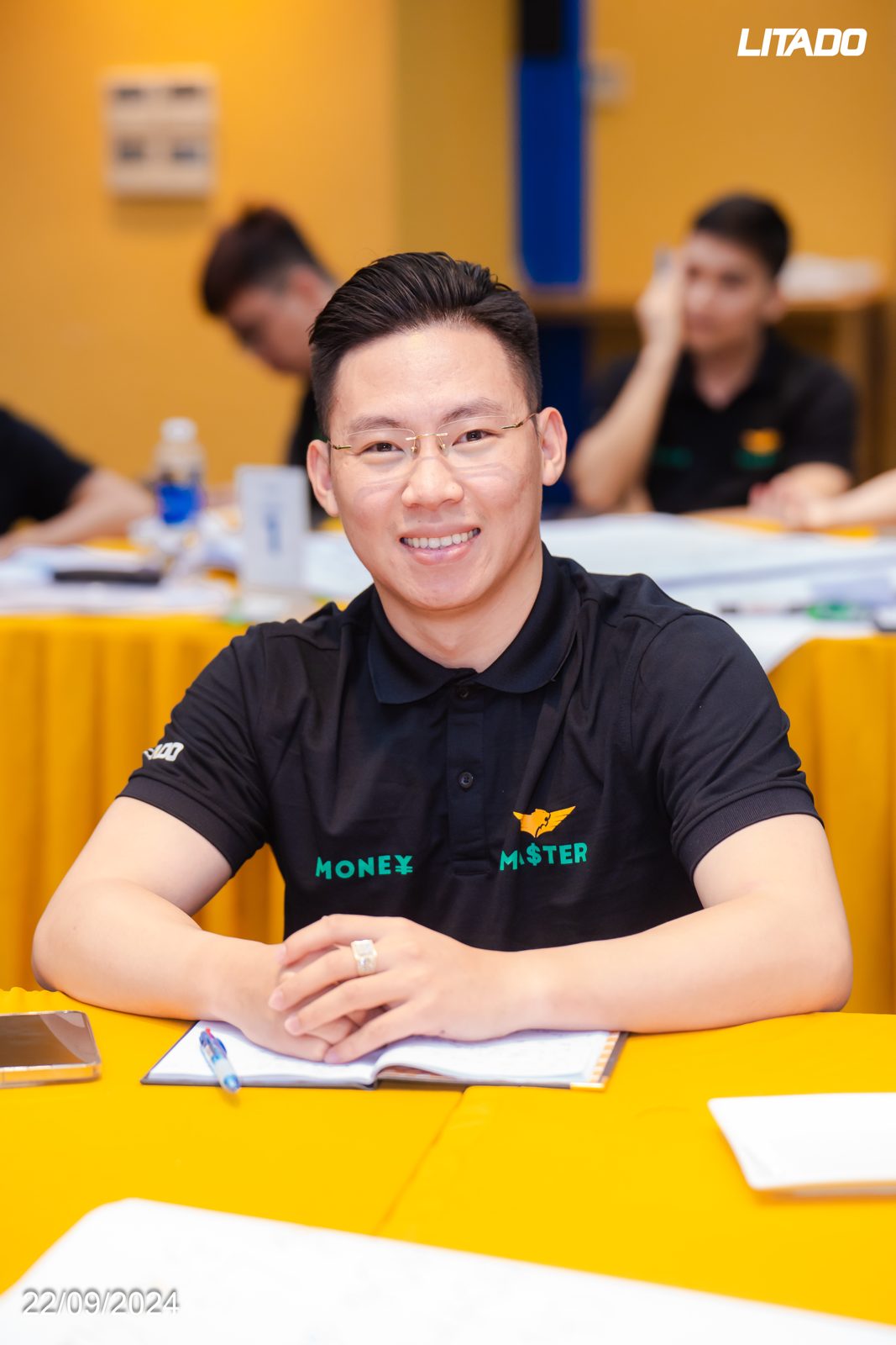 Lê Anh Tuấn ngồi ghi chép tại bàn học, mỉm cười