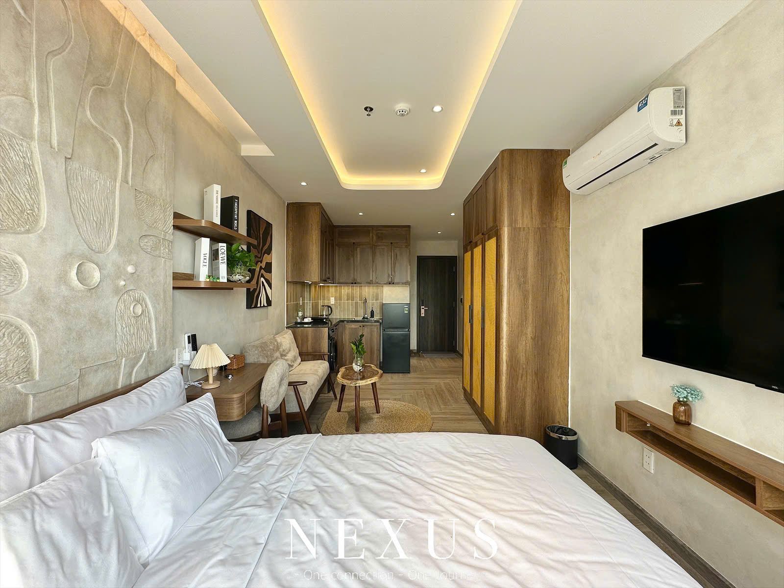 Phòng cho thuê giường lớn, tivi treo tường, tủ gỗ và đèn trần hắt