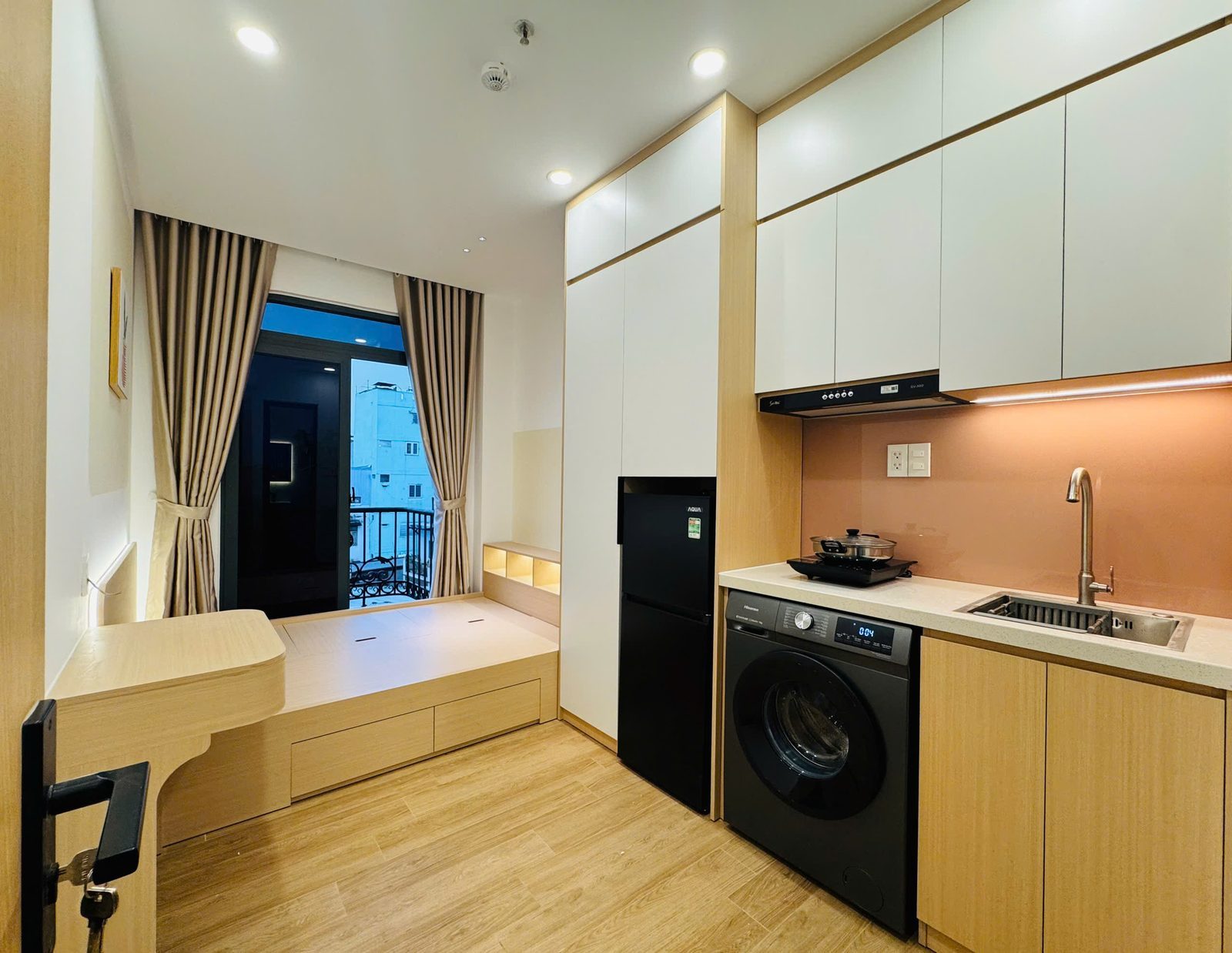 Phòng cho thuê có giường, bếp nhỏ, tủ lạnh và máy giặt