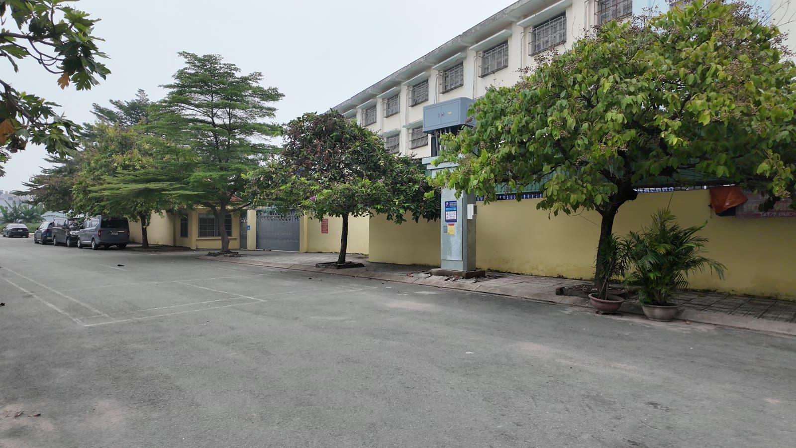 Con đường rộng trước tòa nhà, ô tô đỗ ven đường