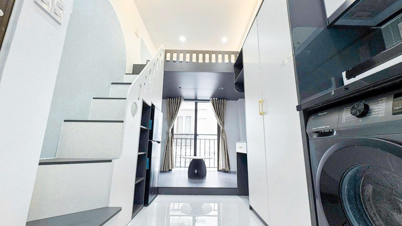 Lối vào một phòng gác lửng sơn trắng, bên phải là bếp và máy giặt, ảnh bìa bài viết về âm dòng tiền khi vay mua nhà