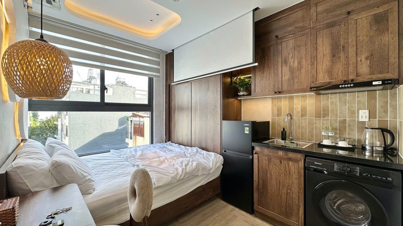Phòng cho thuê có giường cạnh cửa sổ, màn chiếu, tủ lạnh và bếp gỗ, ảnh bìa bài viết về biên độ lãi suất sau ưu đãi