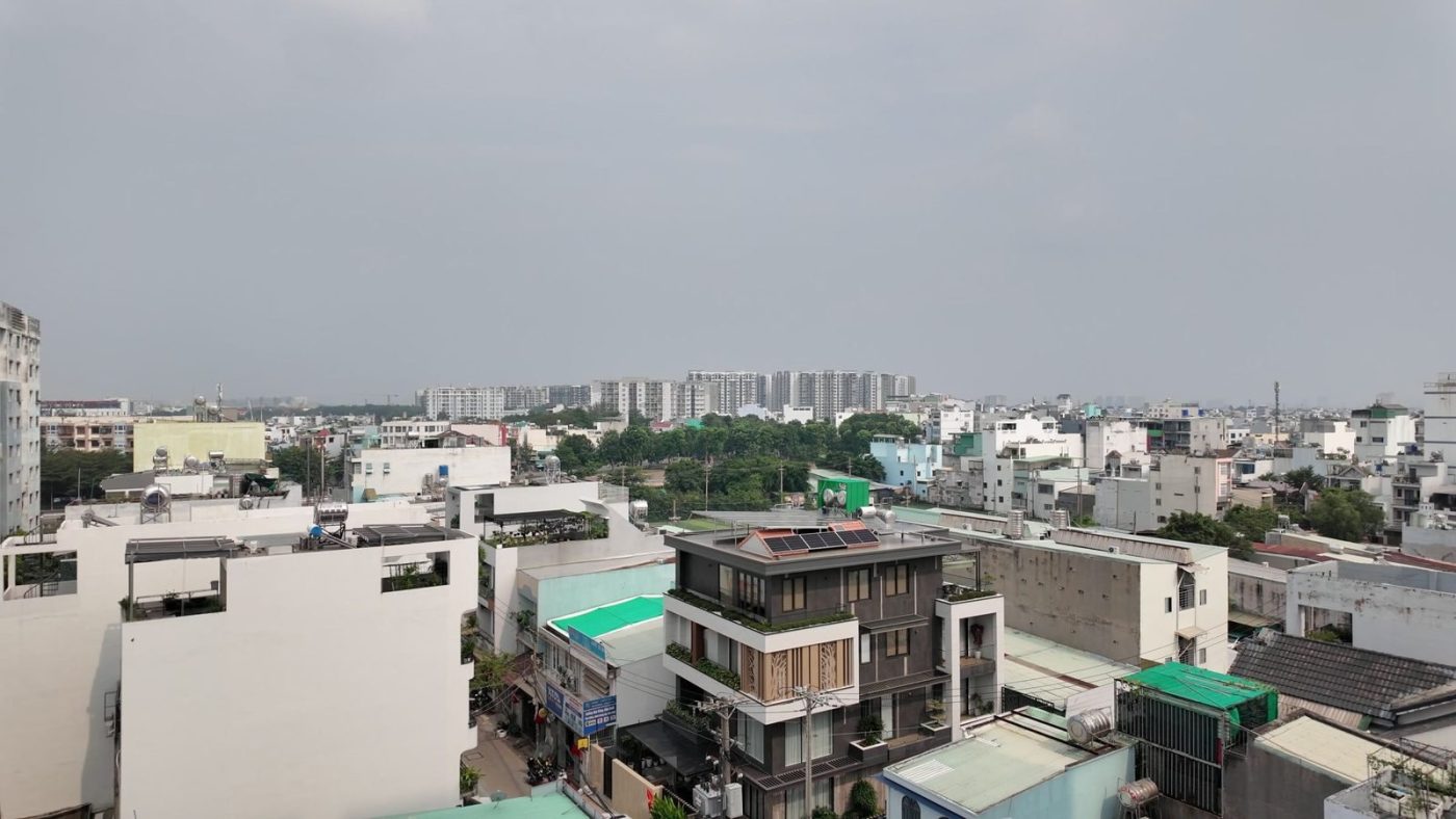 Toàn cảnh một khu dân cư đông đúc nhìn từ trên cao, phía xa là các tòa chung cư