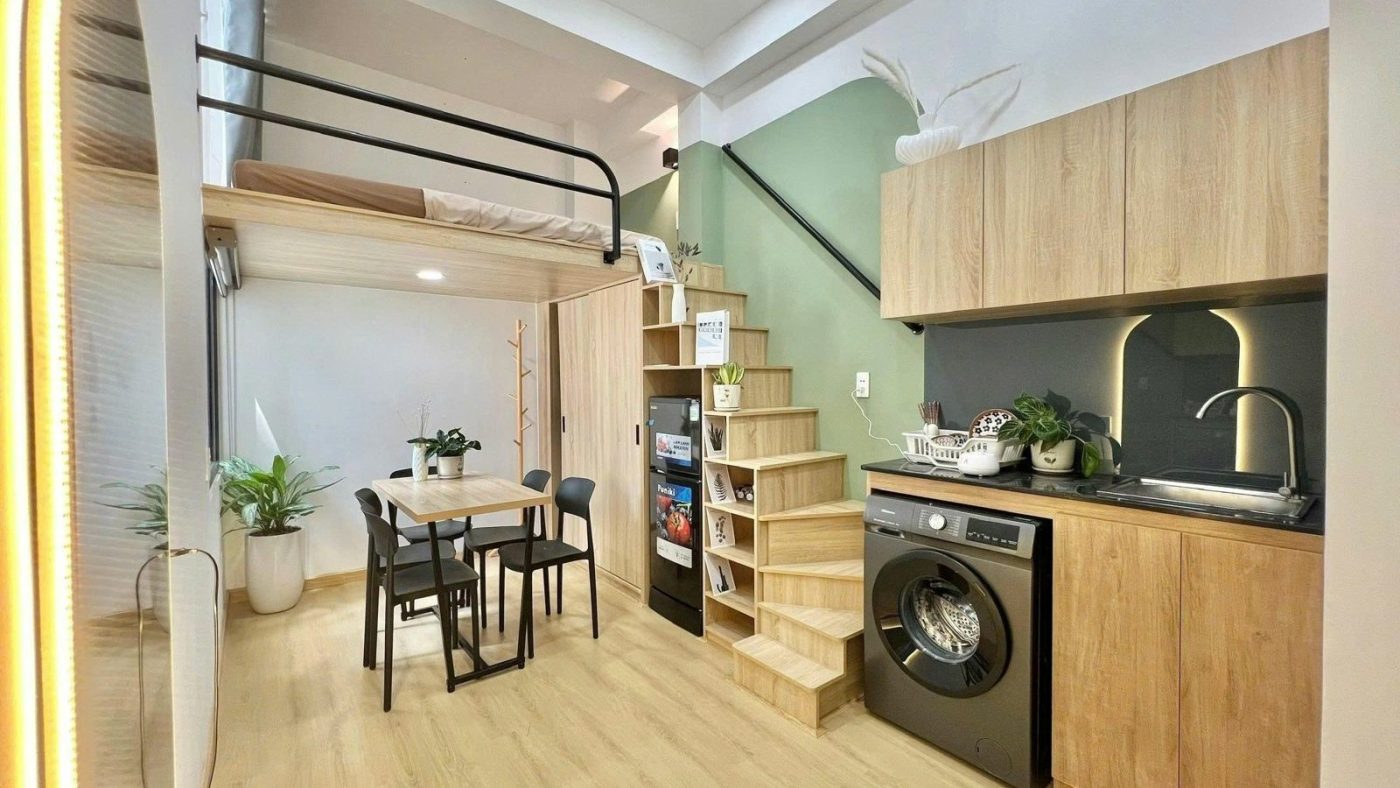 Phòng cho thuê có giường gác lửng bọc kệ gỗ, bếp, máy giặt và bàn ăn nhỏ, ảnh bìa bài viết về câu hỏi nên hỏi môi giới