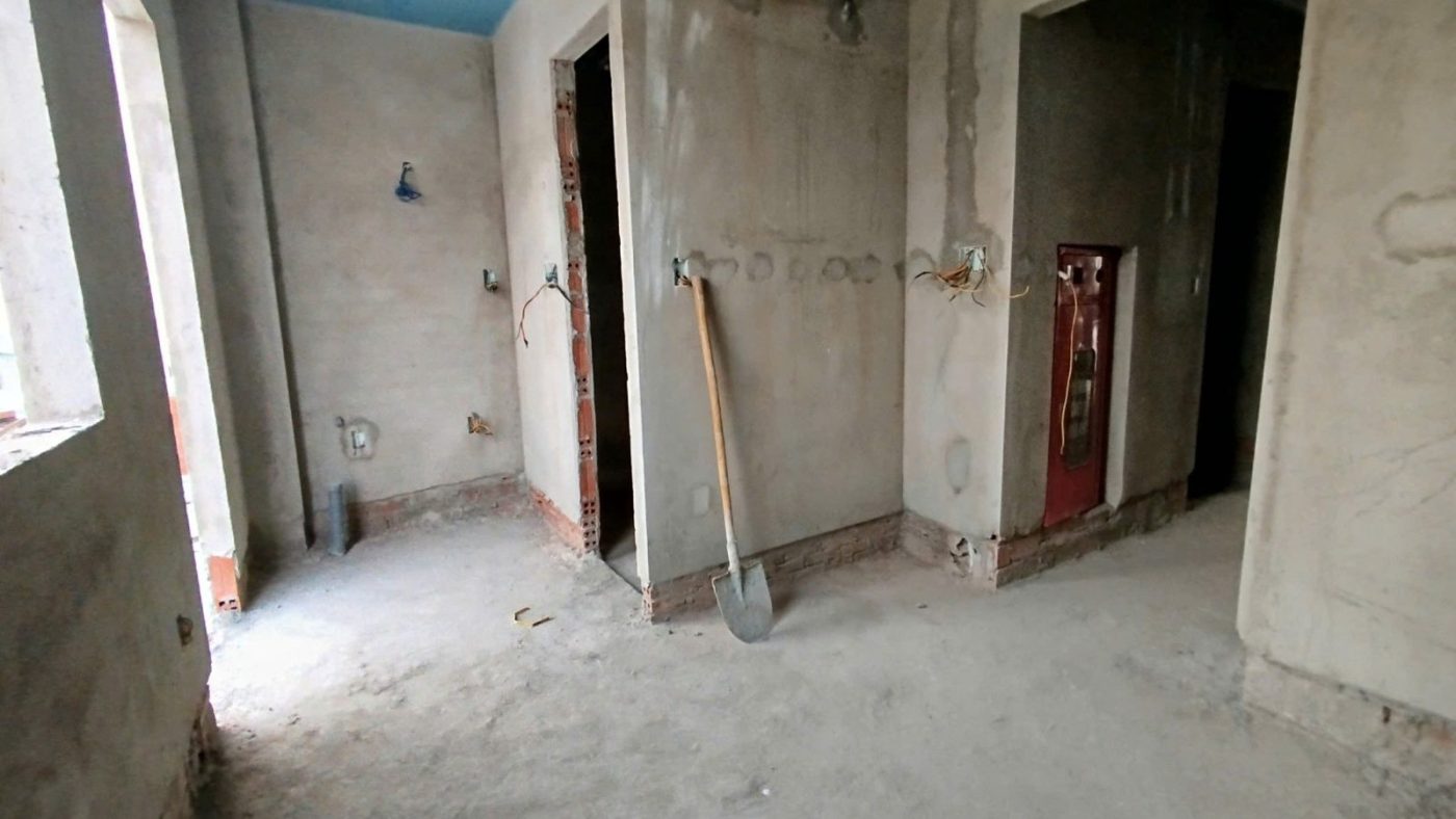 Hộp chữa cháy âm tường vừa lắp trong một tòa nhà đang thi công, tường mới trát, ảnh bìa bài viết về chi phí làm phòng cháy chữa cháy