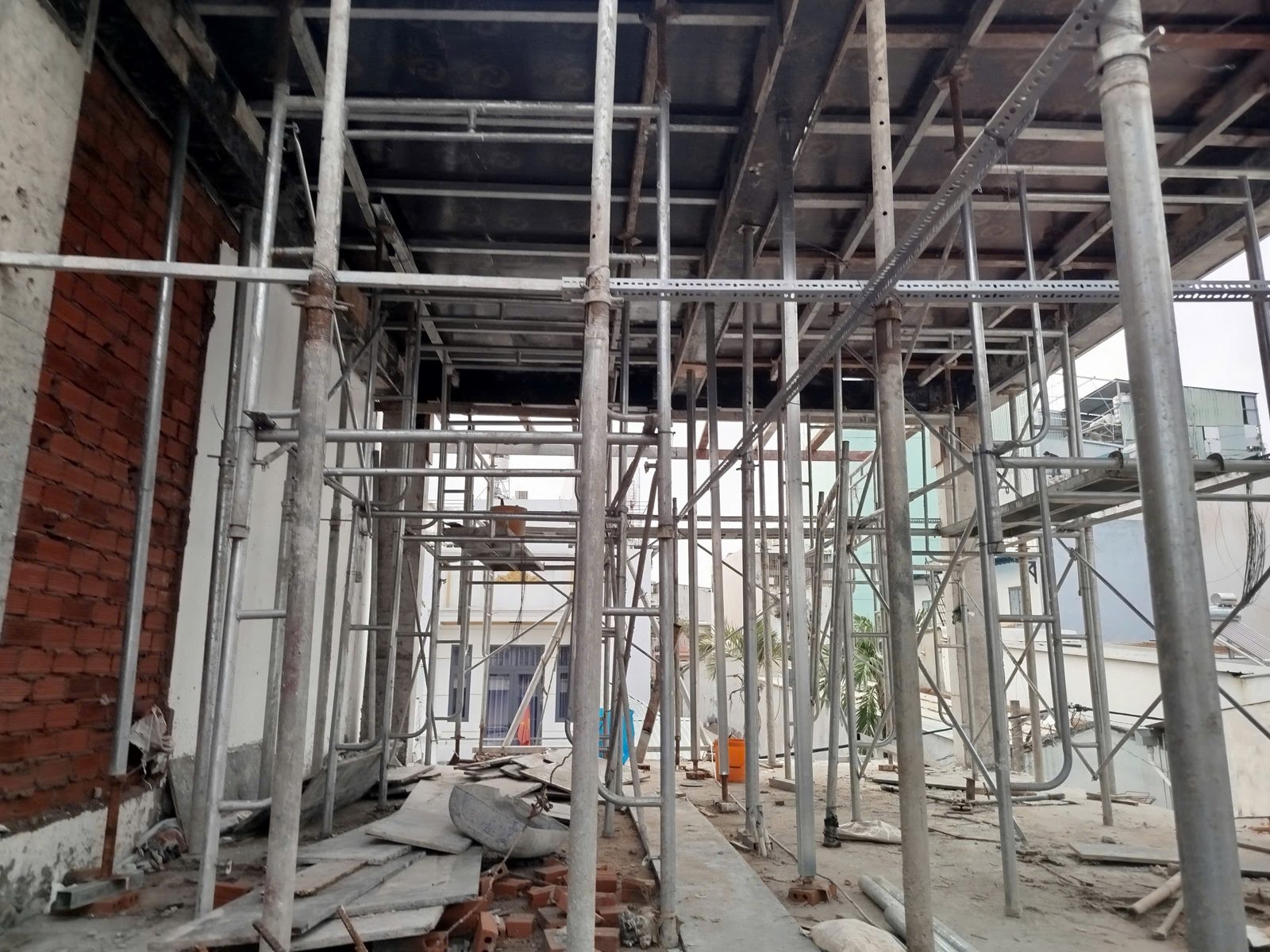 Công trình đang xây dựng giàn giáo thép, tường gạch và tấm sàn bê tông phía trên