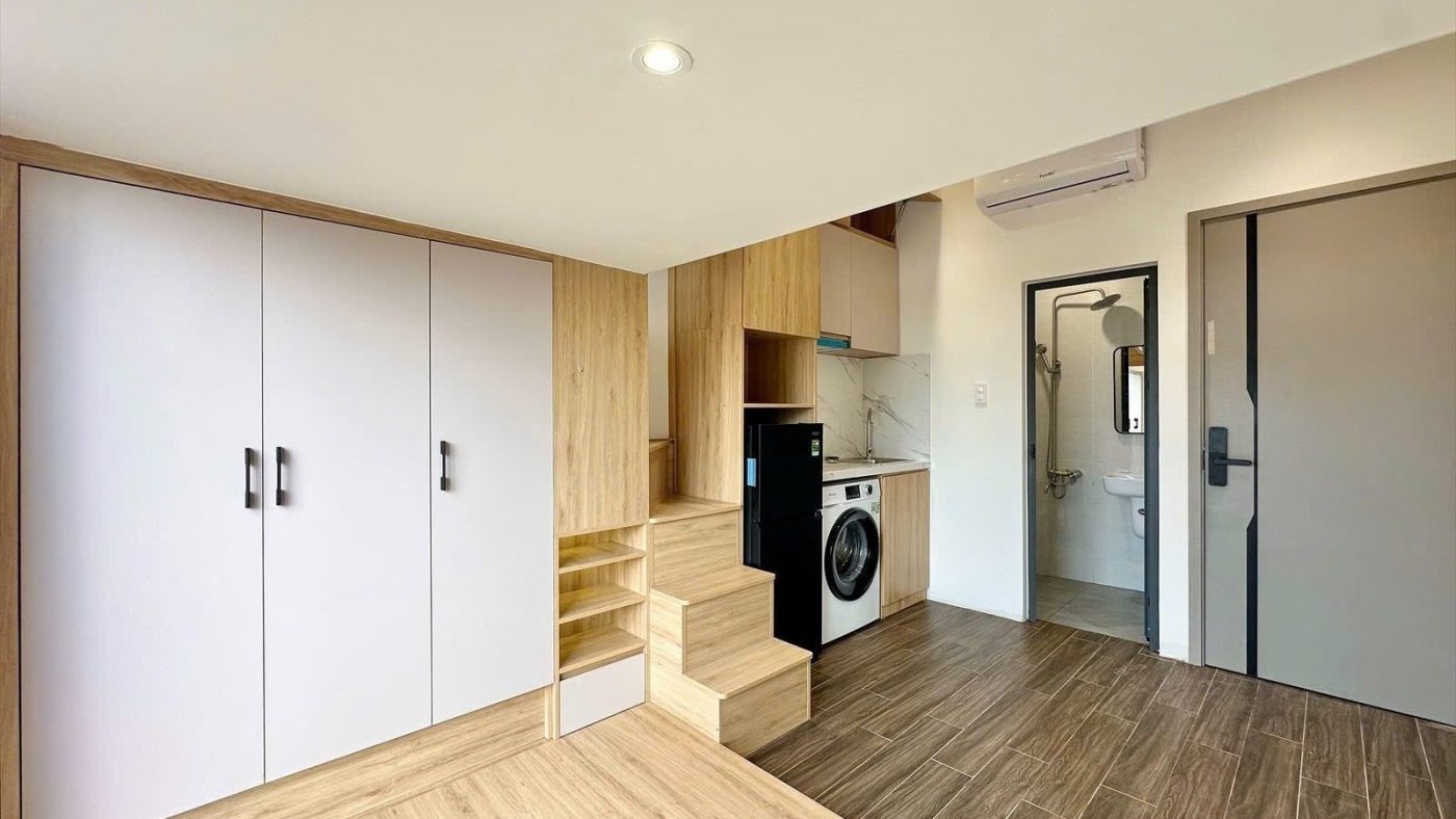 Phòng cho thuê có tủ áo trắng kịch trần, bậc thang gỗ lên gác, tủ lạnh, máy giặt và nhà tắm