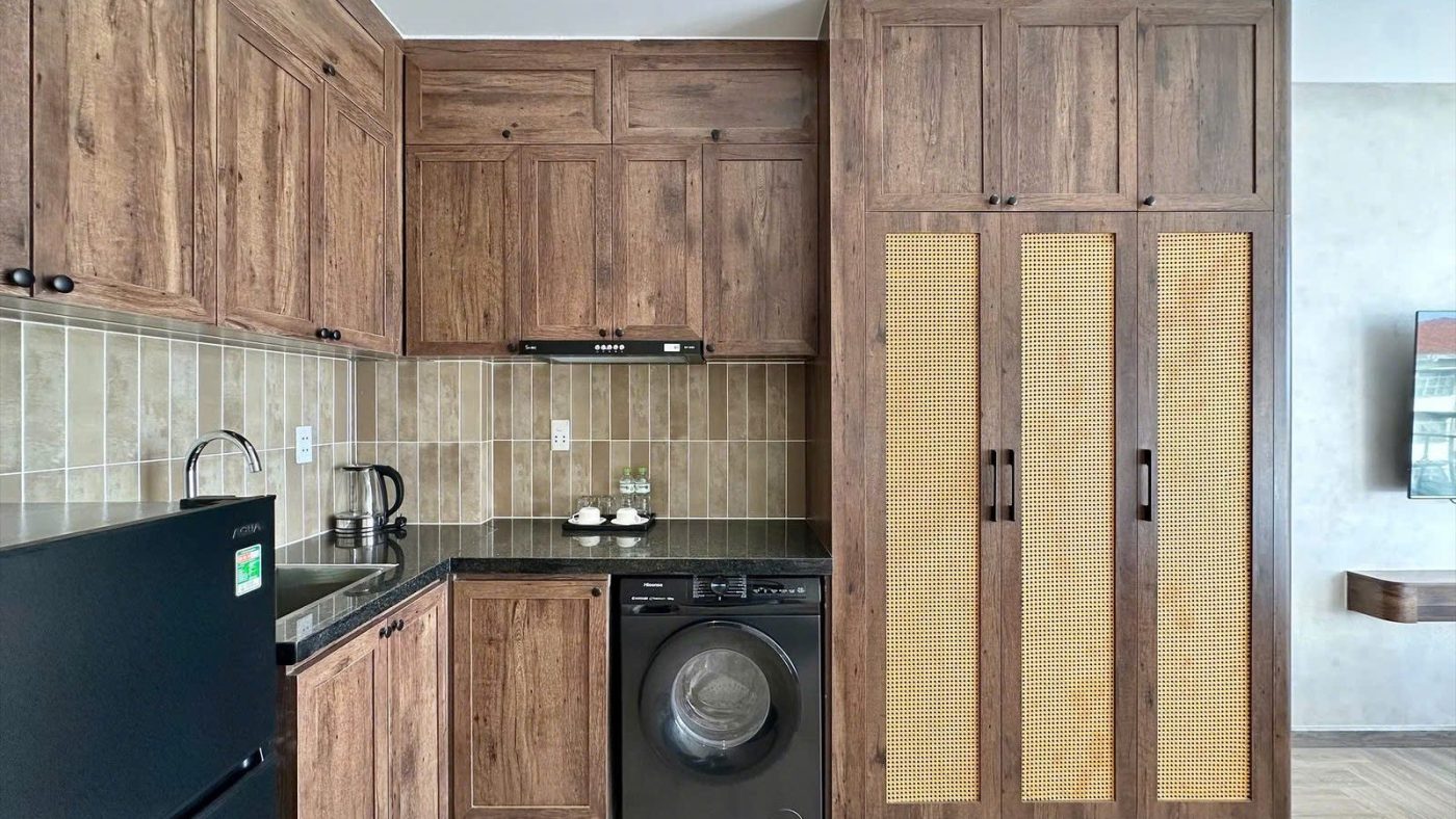 Bếp gỗ, tủ quần áo cánh mây và máy giặt trong một căn hộ dịch vụ, ảnh bìa bài viết về định giá thuê phòng