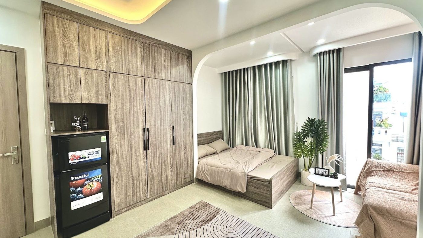 Phòng cho thuê rộng có tủ gỗ kín tường, hai giường và bộ bàn ghế nhỏ, ảnh bìa bài viết về giá khoán lại nhà cho thuê