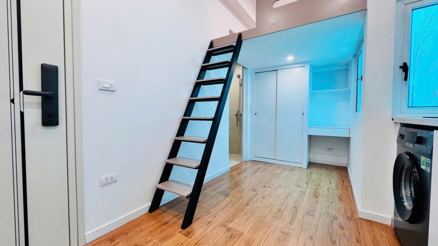Phòng cho thuê có gác lửng, cầu thang sắt đen, sàn gỗ, máy giặt và khóa cửa điện tử