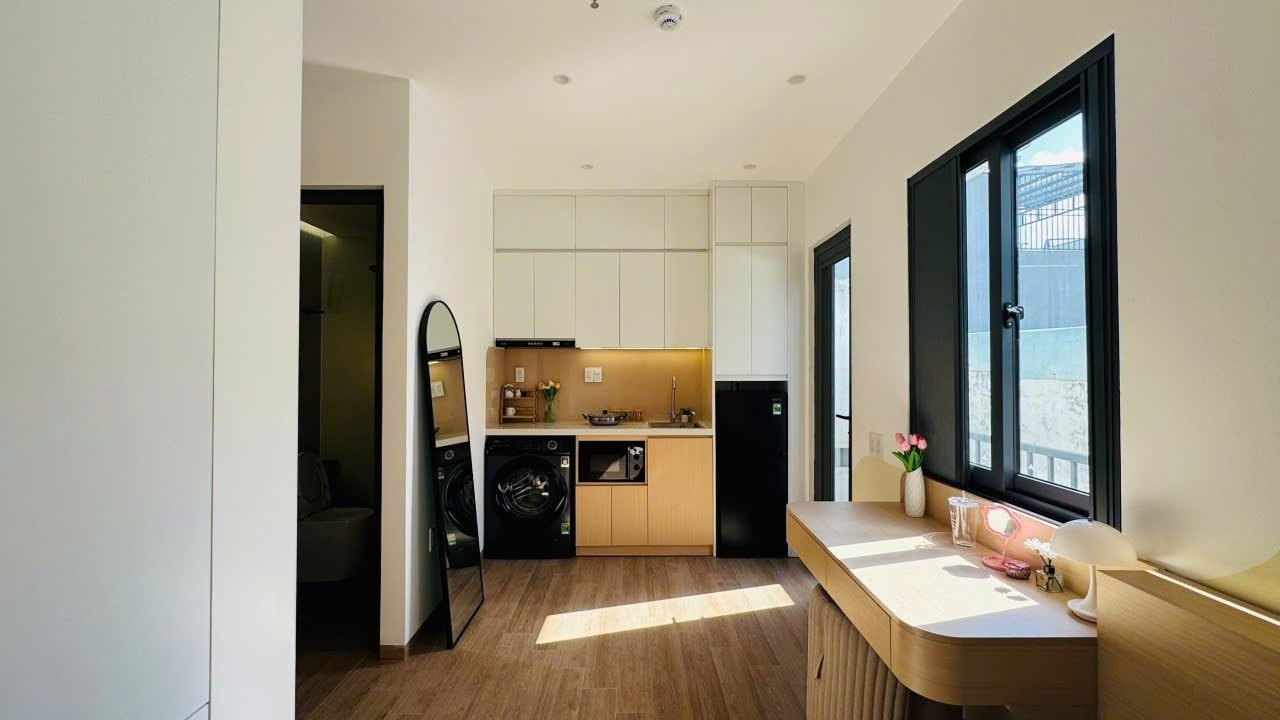 Phòng cho thuê sáng nắng có bếp, máy giặt, tủ lạnh và bàn cong kê cạnh cửa sổ, ảnh bìa bài viết về kiểm tra bảng lợi nhuận nhà cho thuê