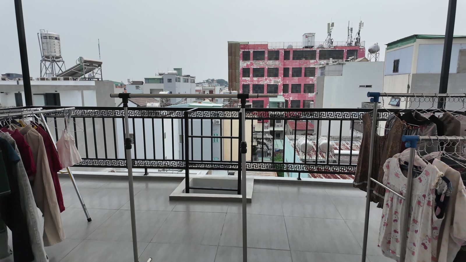 Sân phơi chung trên tầng thượng có giàn phơi quần áo, nhìn ra khu dân cư