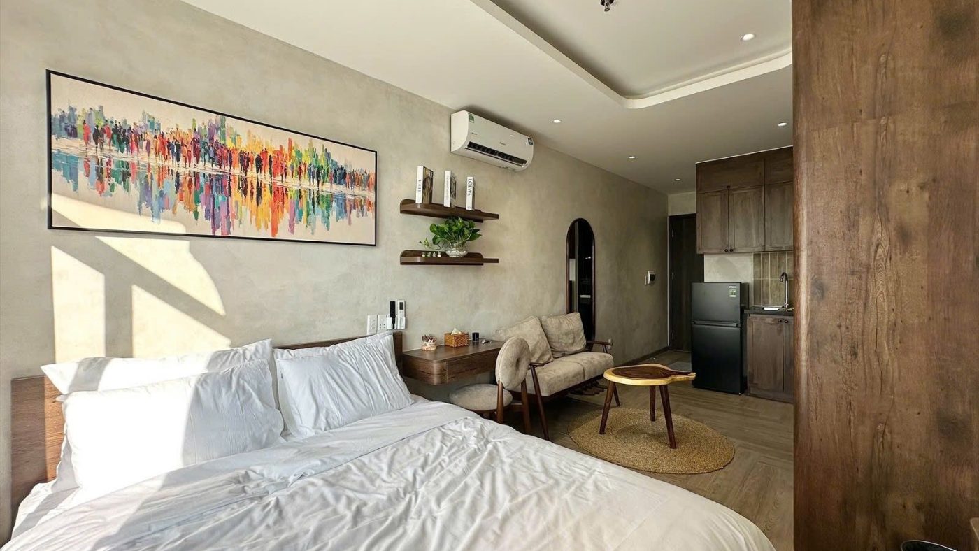 Phòng cho thuê có giường, tranh treo tường nhiều màu và bộ bàn ghế nhỏ, ảnh bìa bài viết về lãi suất tăng 1%