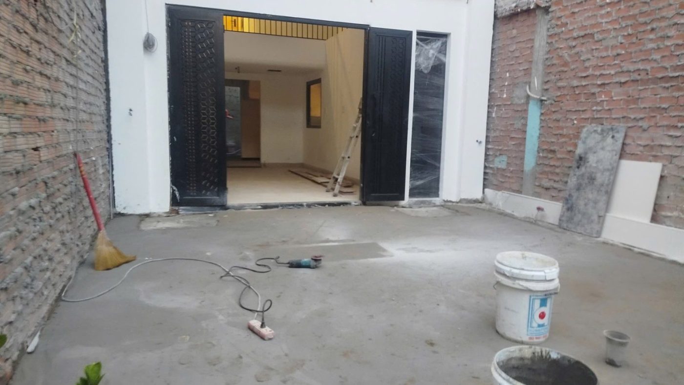 Khoảng sân lùi trước một tòa nhà đang hoàn thiện, hai bên là tường gạch, ảnh bìa bài viết về lộ giới hẻm TP.HCM