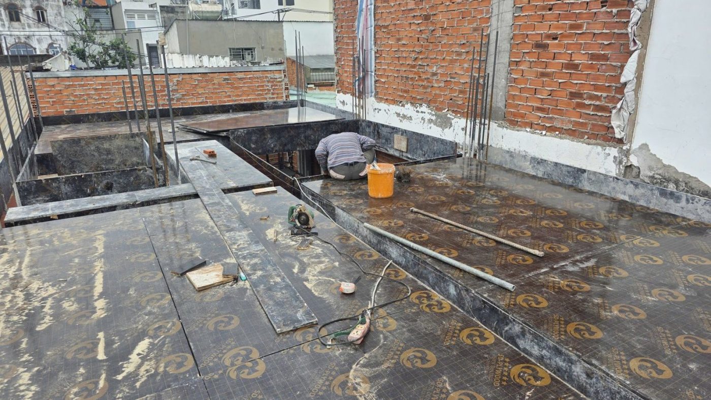 Sàn mái bê tông đang thi công với cốt thép và tường gạch
