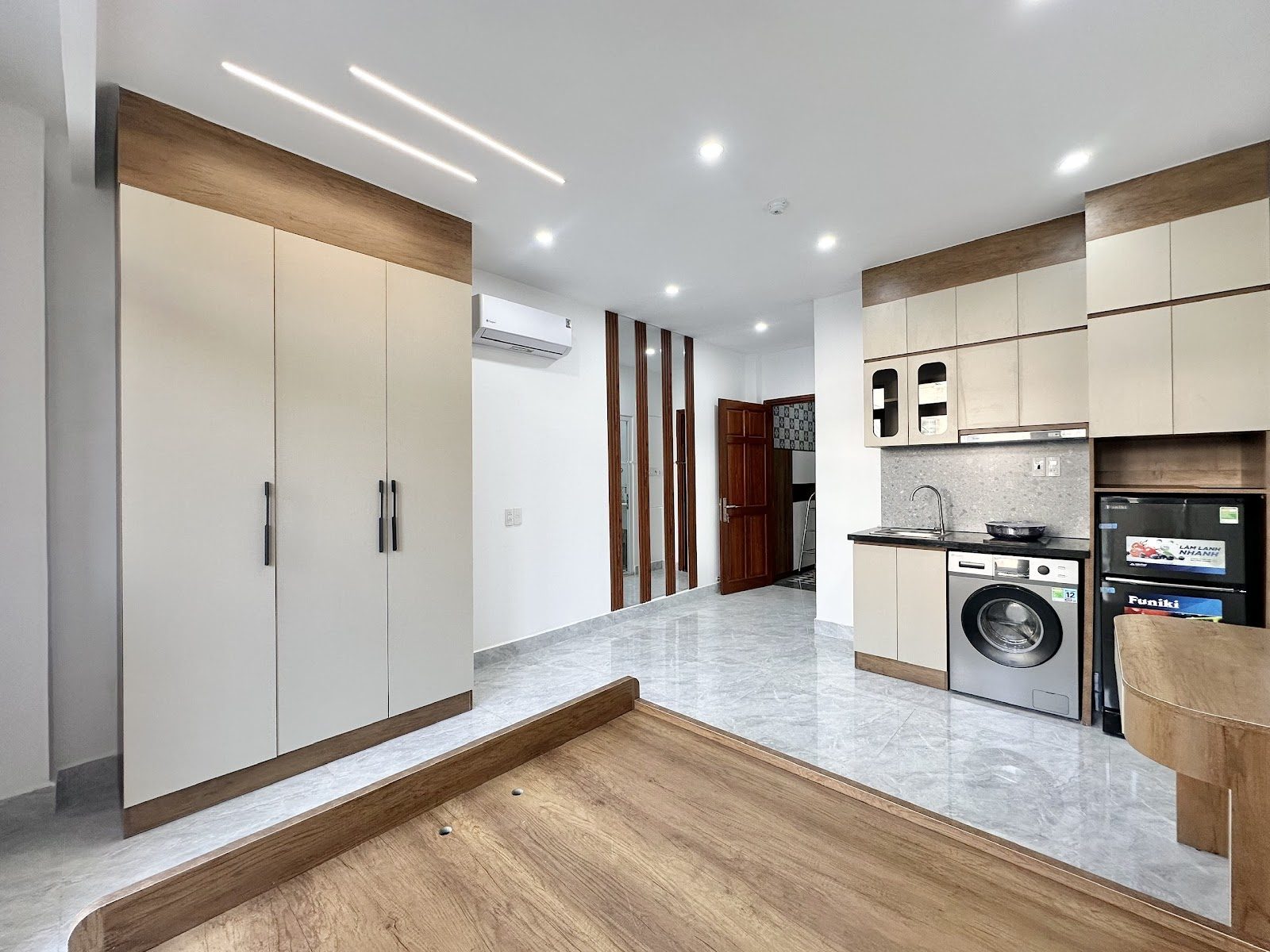 Phòng cho thuê sàn đá xám rộng, tủ áo lớn, bếp, máy giặt và bục giường gỗ
