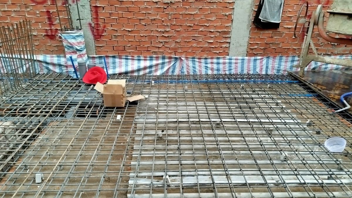 Lưới thép sàn tầng trệt đang thi công giữa các bức tường gạch của nhà liền kề