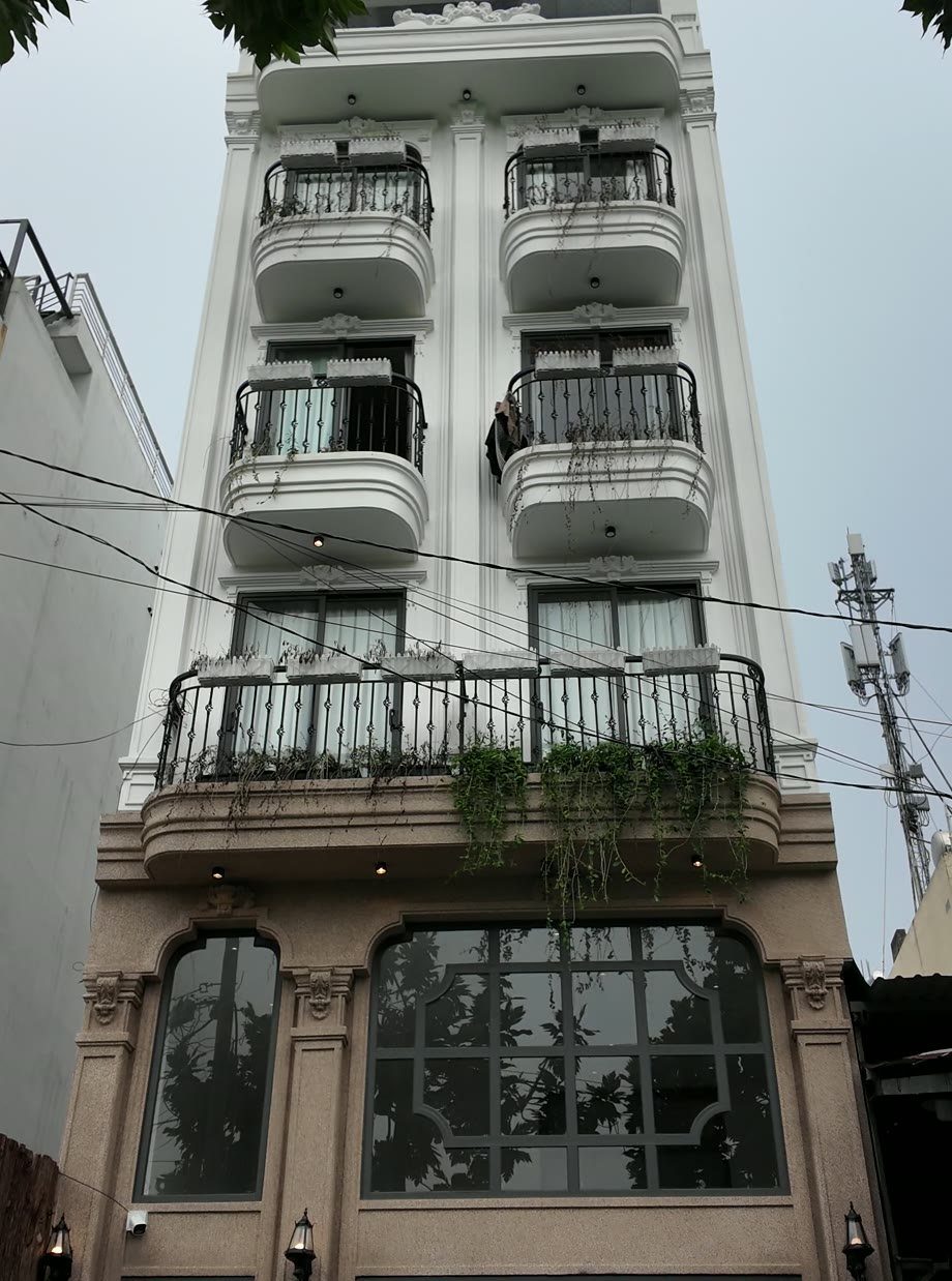 Mặt tiền tòa nhà cho thuê tân cổ điển màu trắng cao nhiều tầng, cửa vòm kính ở tầng trệt
