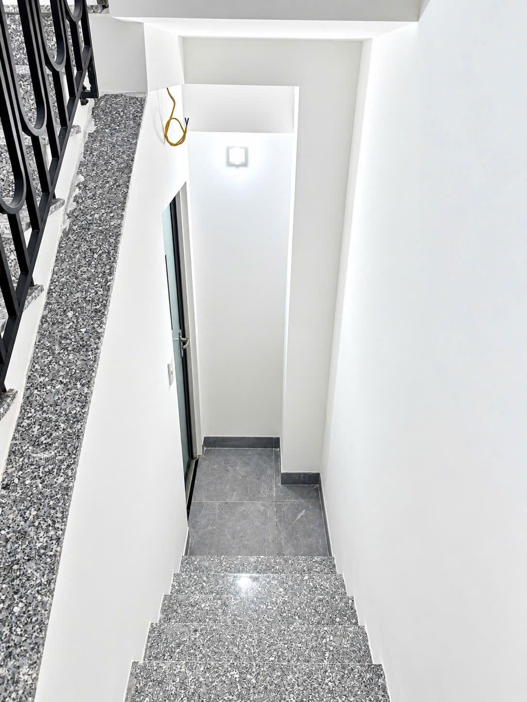 Cầu thang bộ lát đá granite nhìn từ trên xuống, cuối cầu thang là cửa ra