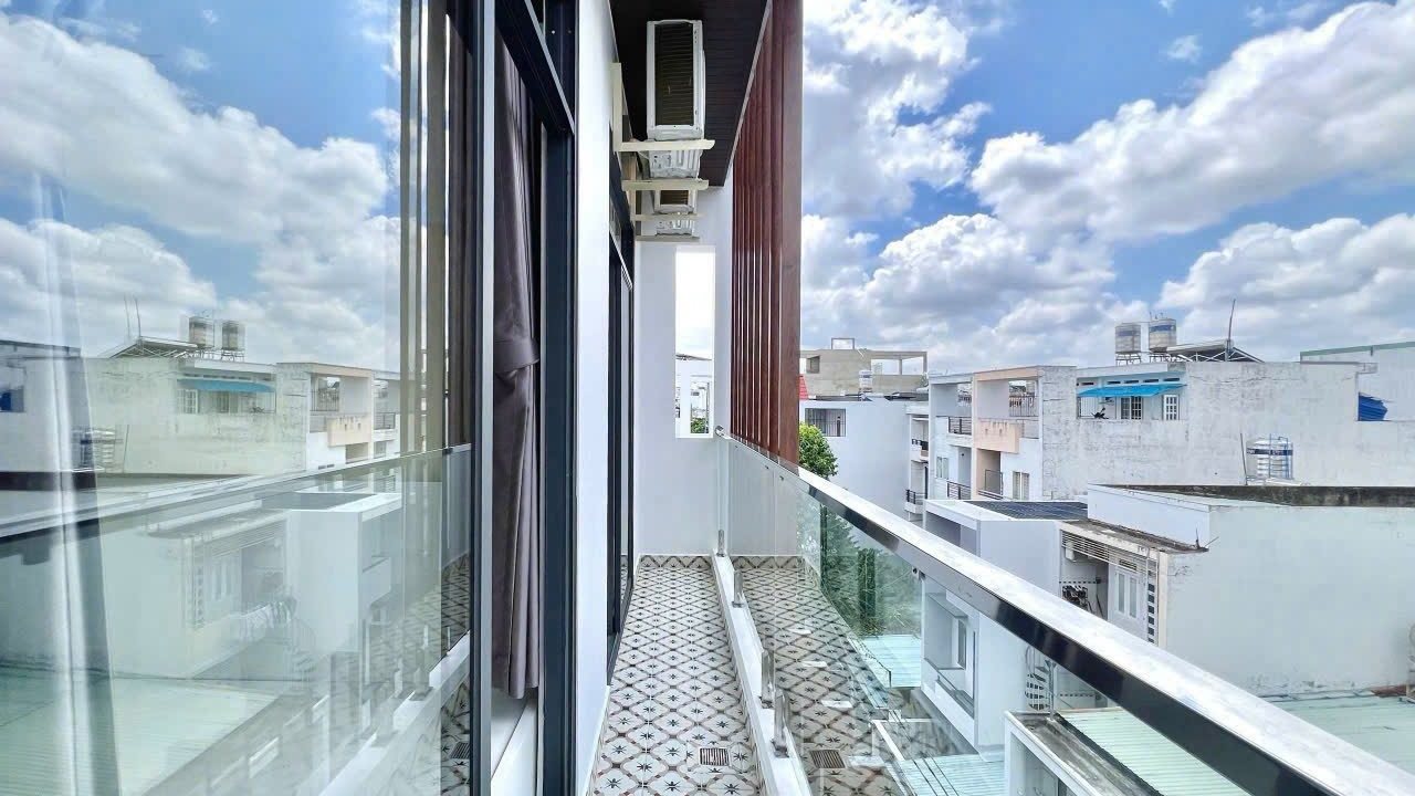 Ban công kính nhìn ra các dãy nhà phố, sàn lát gạch hoa, ảnh bìa bài viết về nhà cho thuê vùng ven TP.HCM