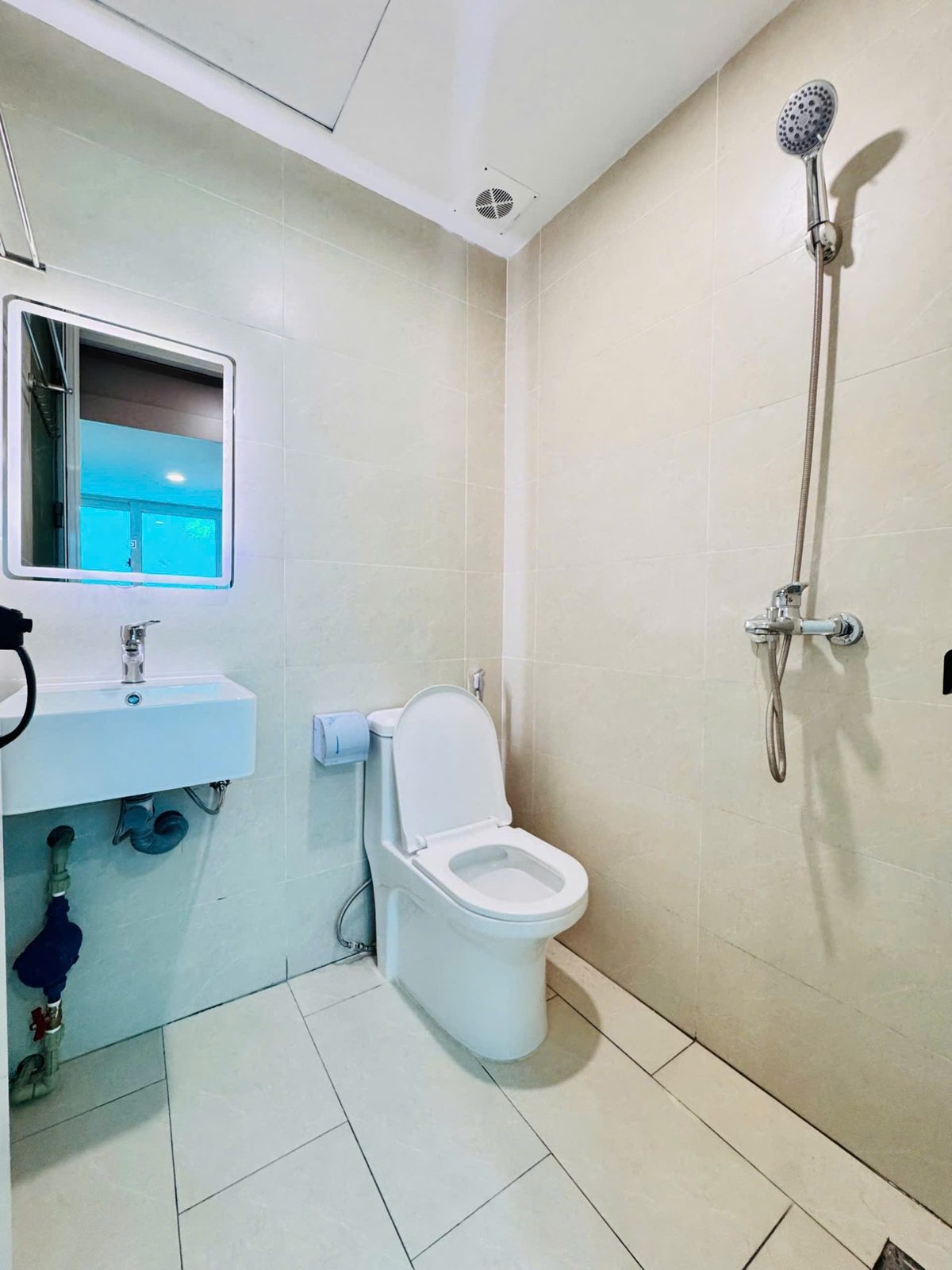 Nhà tắm phòng cho thuê có sen cây, bồn cầu, lavabo và gương