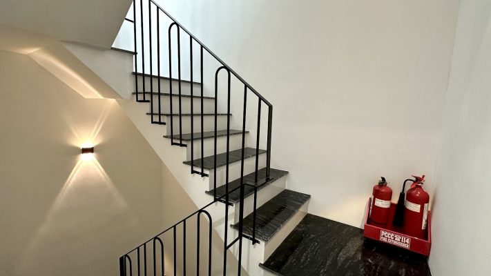 Cầu thang sắt đen lên xuống có hai bình chữa cháy đặt ở chiếu nghỉ, ảnh bìa bài viết về thẩm định độc lập trước khi mua nhà