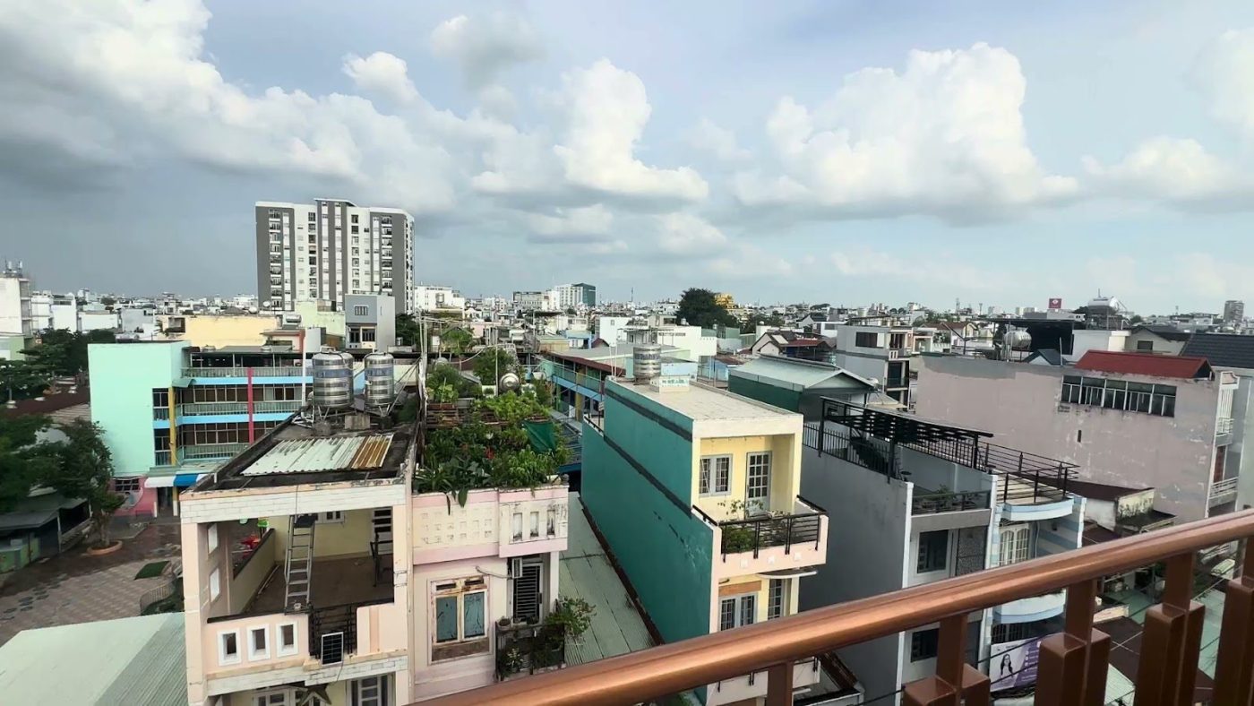 Khu dân cư nhiều tầng nhìn từ ban công tầng cao, xa xa là một tòa chung cư, ảnh bìa bài viết về thế chấp đất nền mua nhà cho thuê
