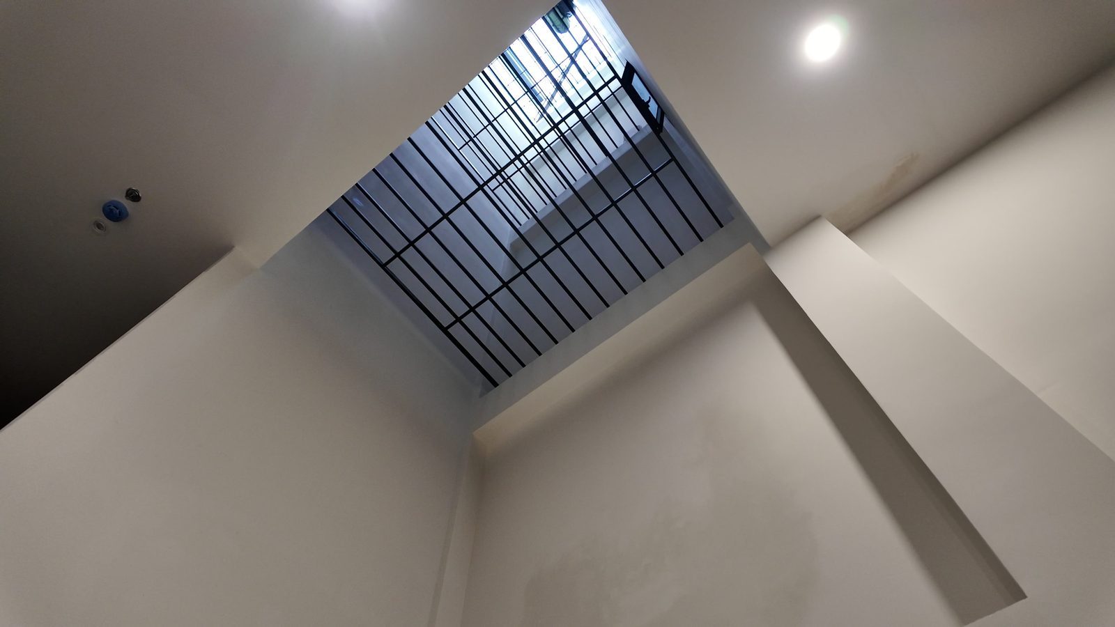 Giếng trời có khung sắt nhìn từ dưới lên trong một tòa nhà cho thuê