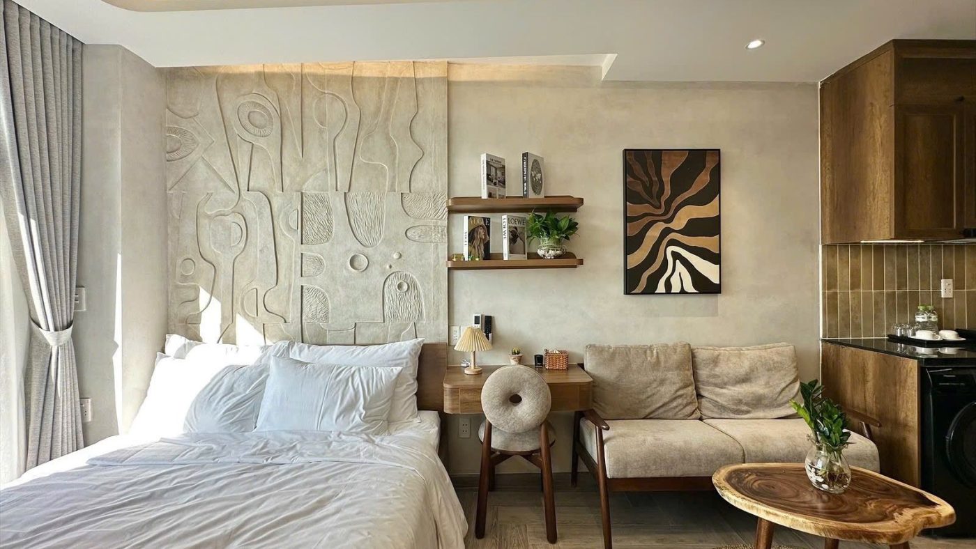 Phòng cho thuê có giường, sofa, bàn gỗ và mảng tường đắp nổi, ảnh bìa bài viết về trách nhiệm chủ nhà khi xảy ra cháy
