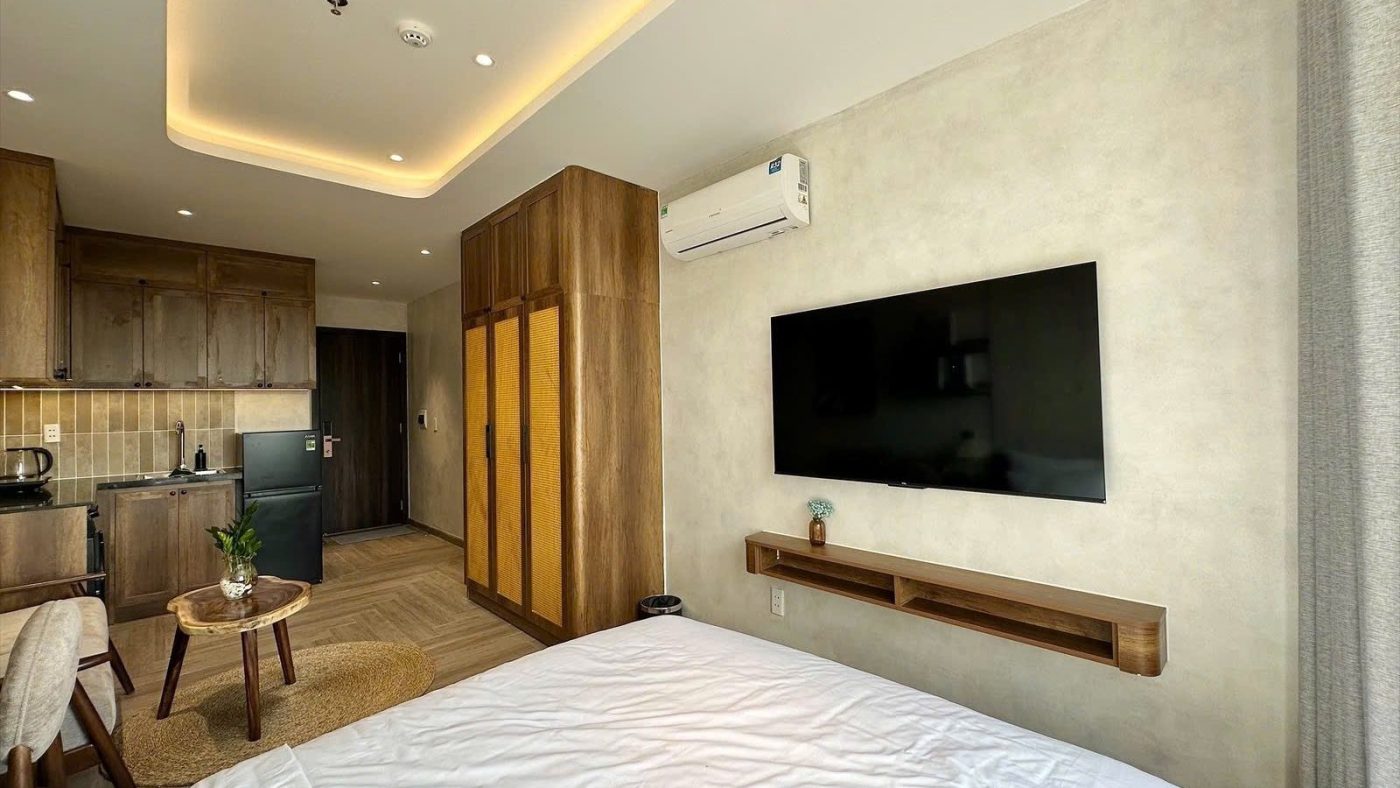 Phòng cho thuê có giường, tivi treo tường, tủ áo gỗ và góc bếp phía trong, ảnh bìa bài viết về vay 10 tỷ mua nhà cho thuê