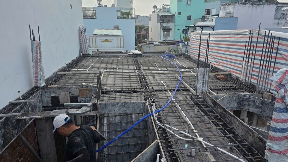 Công nhân đứng trên sàn thép đang thi công của một tòa nhà cho thuê trong khu dân cư